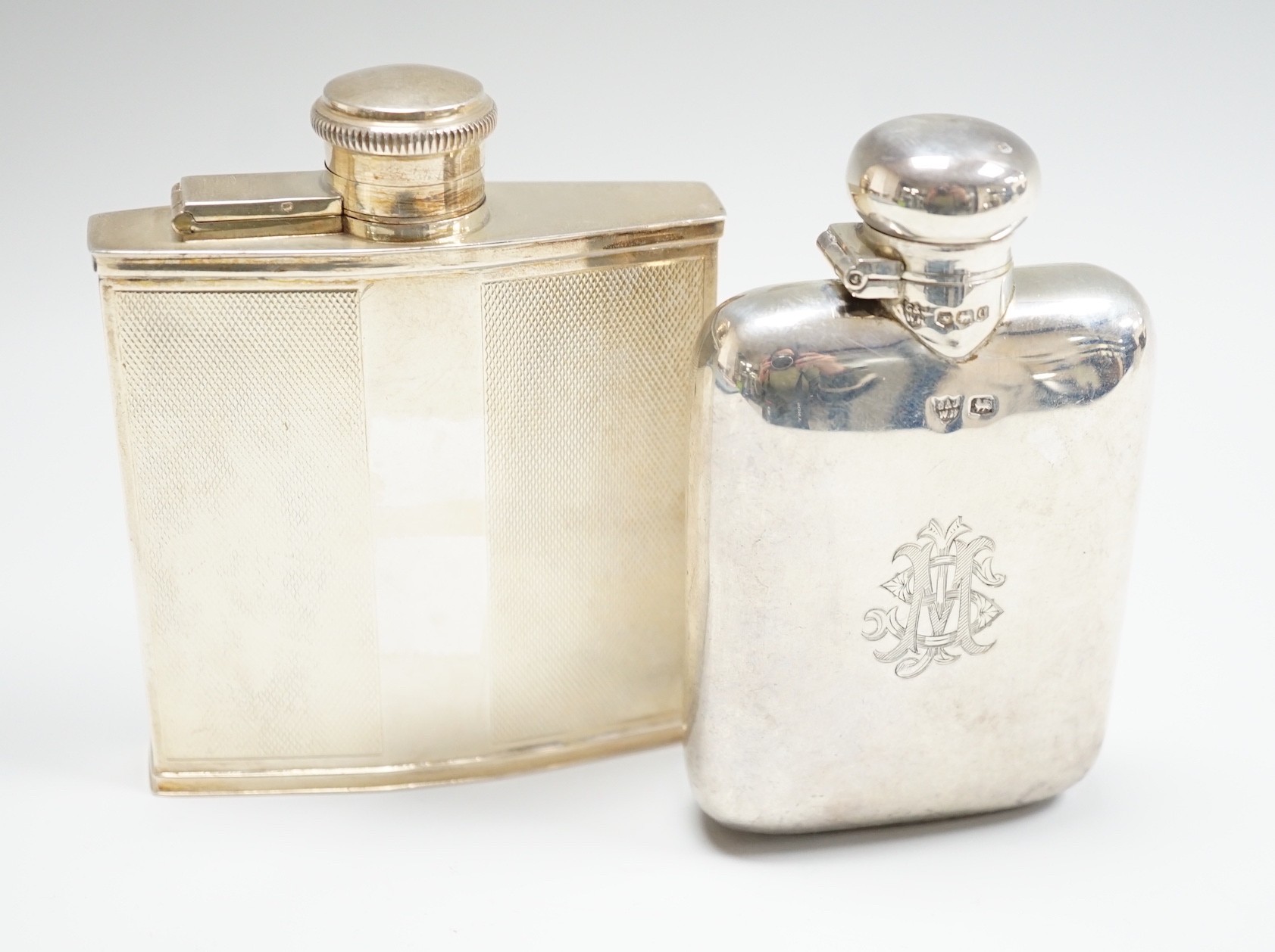 Two George V silver hip flasks, one with engine turned decoration, the latter William Base & Sons, Birmingham, 1927, 10.7cm, 7.7oz.